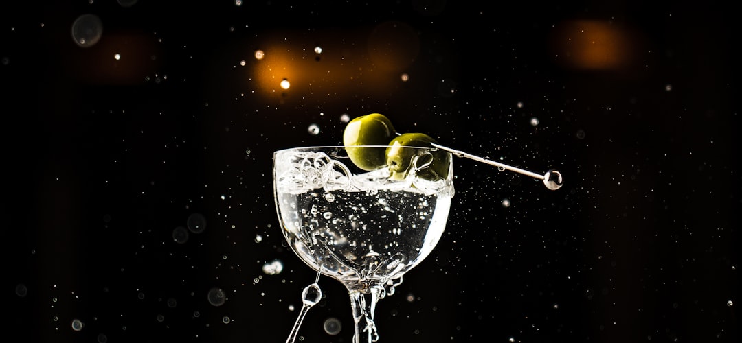 Een foto van een martini cocktail met een olijf